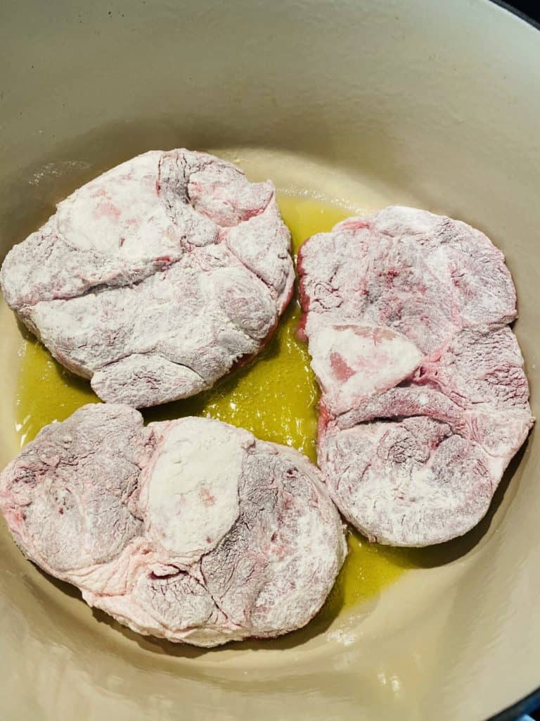 veal shanks searing in a pan 