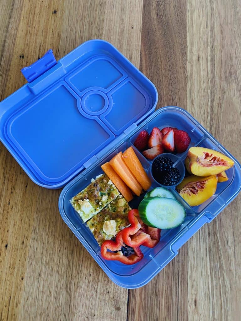 kids lunchbox with zucchini slice and fresh fruit and vegetables 
