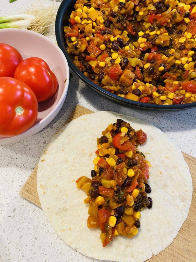 Roasted veggie enchiladas, dividing the filling between the tortillas